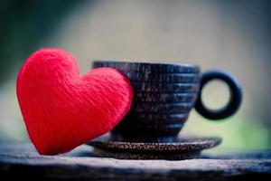 Heart in wooden coffee cup with romantic love valentines day on wood background - love coffee concept photo