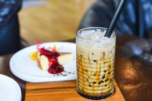 Bubble milk tea in glass on the wooden table with cake - Taiwan milk tea photo