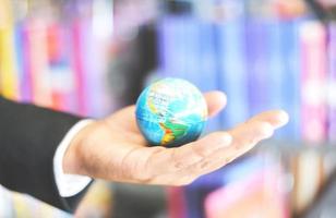 Business man holding earth globe model in hand and - Business global and travel around the world or save the world concept photo