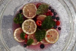 A Glass Bowl With Citrus Fruit Slice And Berry On The White Table. photo