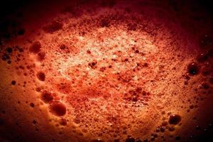 Dark red image of foam on liquid surface. Abstract red foam background. photo