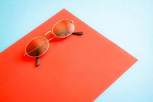 Golden sunglasses on red and blue backgound. photo