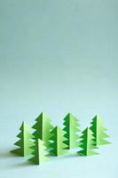 Paper forest with free copy paste space for text. Green paper trees on blue background. photo