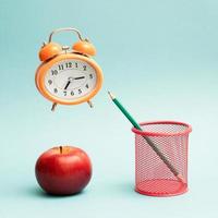 Surreal minimalist concept with a flying alarm clock on blue background. photo