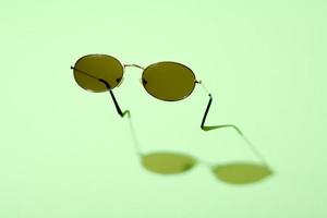 Abstract minimalist image of standing sunglasses on blue background. photo