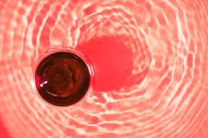 Glass or red wine top view with abstract red background. photo
