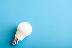 White lightbulb on blue background with free copy paste space for text. photo