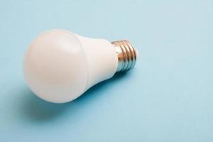 White economy light bulb on bue background with free copy paste space. photo