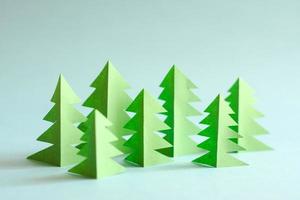 Green paper forest on blue background. Paper trees. photo