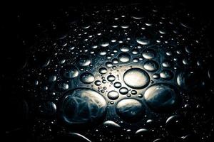 Abstract dark shiny background with droplets. Droplets background with a dim spotlight. photo