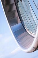 Part of a modern building. Oval shaped futuristic building built with metal and glass. photo