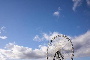 Ferris wheel with white cabins and two black photo