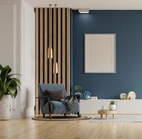maqueta de afiches con marcos verticales en una pared vacía de color azul oscuro en el interior de la sala de estar con sillón de terciopelo azul. foto