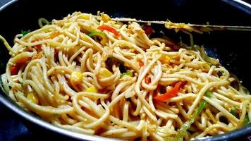 Schezwan Noodles or Szechwan vegetable Hakka Noodles or chow mein is a popular Indo-Chinese recipes, served in a bowl or plate photo