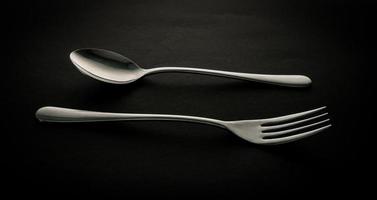 Stainless steel fork and spoon on dark background photo