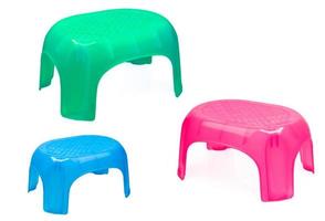 Plastic stool for bathroom or kitchen. Children chair. Green, blue, and pink plastic stool isolated on white background. Stepping stool for adult and kids. Portable and light weight step stool. photo