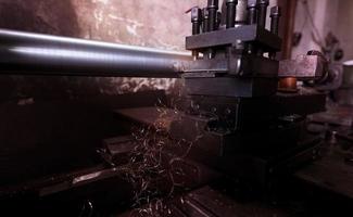 Lathe machine working in factory. Lathe turning machine for metalwork. Heavy machinery manufacturing. Machine for milling metal. Manual lathe machine. Safety in industrial workplace. Steel industry. photo