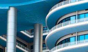 Closeup white and blue building with glass window. Modern architecture. Exterior building. Architectural details of modern building. Facade of office building. Property construction concept. photo