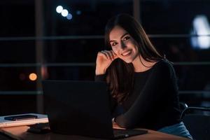 atractiva mujer de negocios morena trabaja sola en la oficina por la noche foto