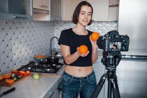 Expensive camera. Girl in the modern kitchen at home at her weekend time in the morning photo