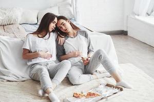 It's not even fun at this moment. Twins have full stomach with pizza. Nice bedroom at daytime photo