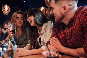 Hard laughings. Beautiful youth have party together with alcohol in the nightclub photo