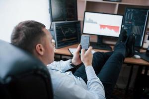 Business owner. Man working online in the office with multiple computer screens in index charts photo