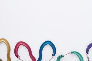Abstract conception. Many of the multi colored carabiners on lying on the white table photo