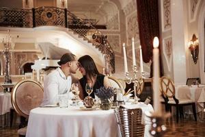 Satisfaction between these two lovers. Beautiful couple have romantic dinner in luxury restaurant at evening time photo
