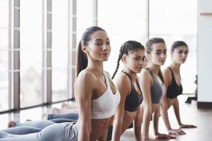 Positive people. Group of sportive girls in a spacious gym with big windows have training photo