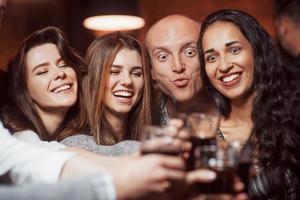 Going crazy. Beautiful youth have party together with alcohol in the nightclub photo