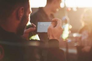 I'm going to capture, be sure you are ready. Taking picture of friends at the rooftop at nice sunny autumn day photo