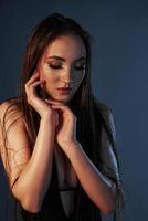 Pure tenderness. Girl with massage oil on her body posing in the studio against blue background photo