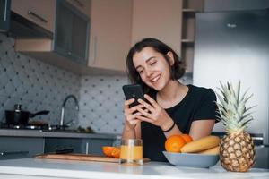 Some funny stuff. Girl in the modern kitchen at home at her weekend in the morning time photo