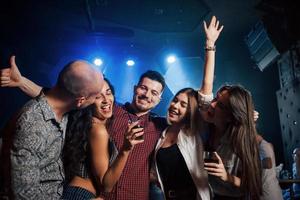 Closeness between guy on the left and girl. Beautiful youth have party together with alcohol in the nightclub photo