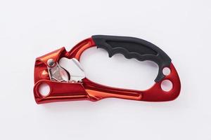 Modern technology for tourism. Isolated photo of climbing equipment - red colored part of carabiner