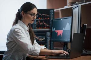 Team of stockbrokers are having a conversation in a office with multiple display screens photo