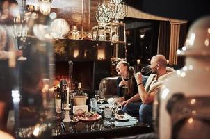 Loud laughing. Girl with her boyfriend have nice evening at beautiful restaurant photo