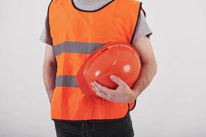 Part of the body. Man in orange colored uniform stands against white background in the studio photo