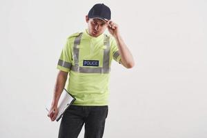 I'll be your helper today. Policeman in green uniform stands against white background in the studio photo