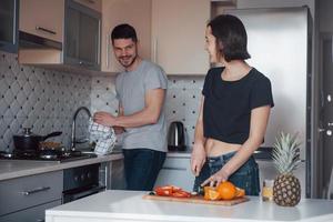 Preparing the food. Young couple in the modern kitchen at home at their weekend time in the morning photo