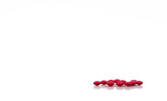 Red pills isolated on white background with copy space for text and clipping path. Global healthcare concept. Vitamin B Complex for convalescent and geriatric patients and peripheral neuritis. photo