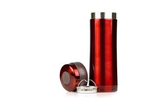 Red thermos bottle opened cap isolated on white background. Coffee or tea reusable bottle container. Thermos travel tumbler. Insulated drink container. Stainless steel thermos water flask. Zero waste. photo