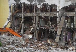 Destroyed building industrial. Building demolition by explosion. Abandoned concrete building with rubble and scrap. Earthquake ruin. Damaged or collapsed building from hurricane disaster. photo