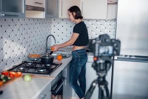 ropa casual. chica en la cocina moderna de casa a la hora del fin de semana por la mañana foto