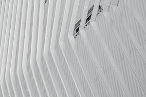 White facade building abstract background. Modern futuristic facade building. Steel cladding corrugated metal sheet facade of building. Exterior building wall architecture. Facade pattern design. photo