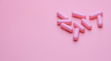 Pink capsule pills on blue background. Online pharmacy banner. Group of capsule pills. Pharmaceutical industry. Drug development and new drug research for treatment emerging Infectious diseases. photo