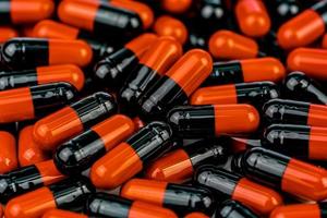 Pile of orange-black capsule pills. Antibiotics resistance. Drug use with reasonable. Global healthcare concept. Antibiotics drug resistance. Antimicrobial capsule pills. Pharmaceutical industry.
