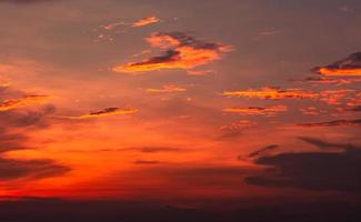 Dramatic red and orange sky and clouds abstract background. Red-orange clouds on sunset sky. Warm weather background. Art picture of sky at dusk. Sunset abstract background. Dusk and dawn concept photo