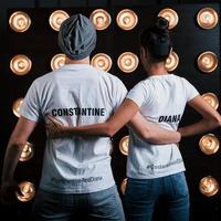 Hugs each other. Back view of couple in shirts with their names on it standing next to studio lights photo